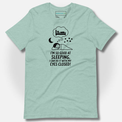 Soft heather clay t-shirt with a humorous sleeping parent design and "I'm so good at sleeping, I can do it with my eyes closed!" text, perfect for tired parents and funny parenting.