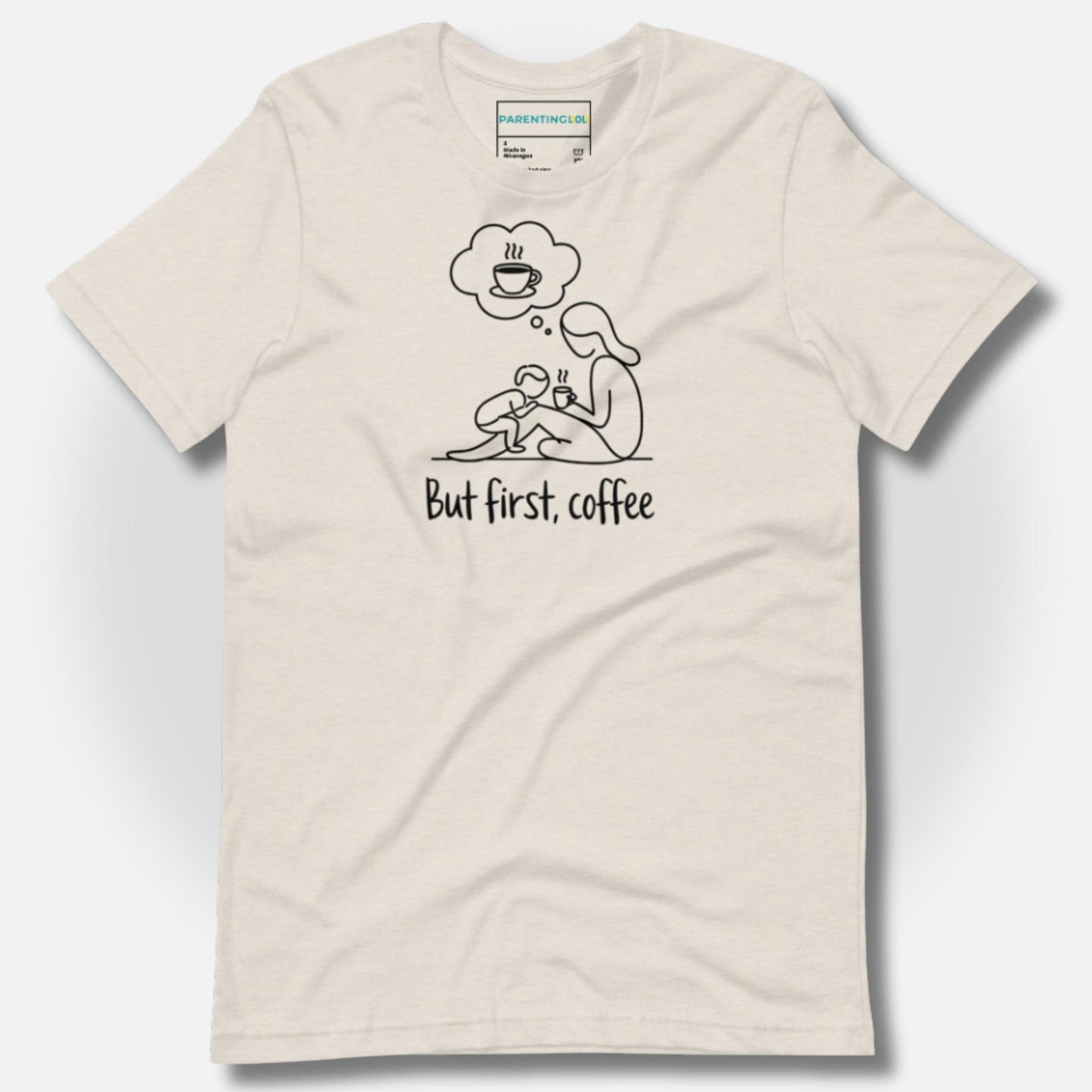 Detail of ParentingLOL's heather dust t-shirt, featuring the "But first, coffee" design, a cozy essential for the busy parent tribe.