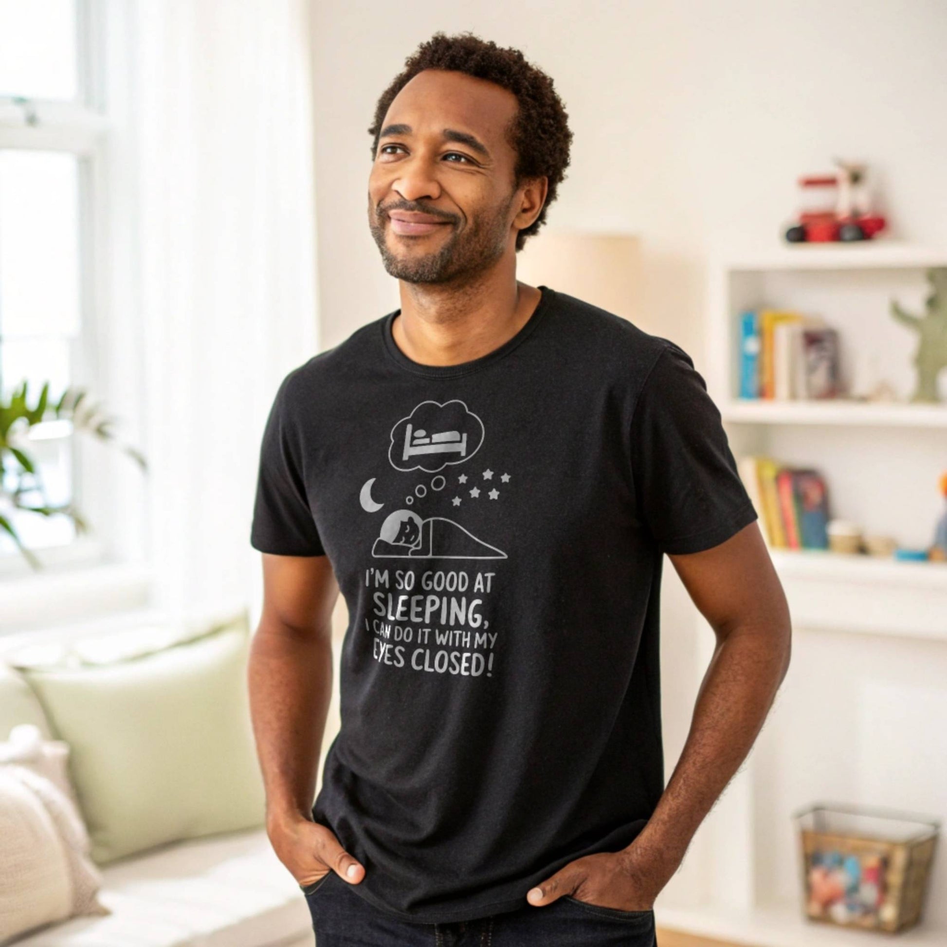 Man smiling in a black "I'm so good at sleeping" t-shirt, representing relaxed parent humor and everyday comfort.