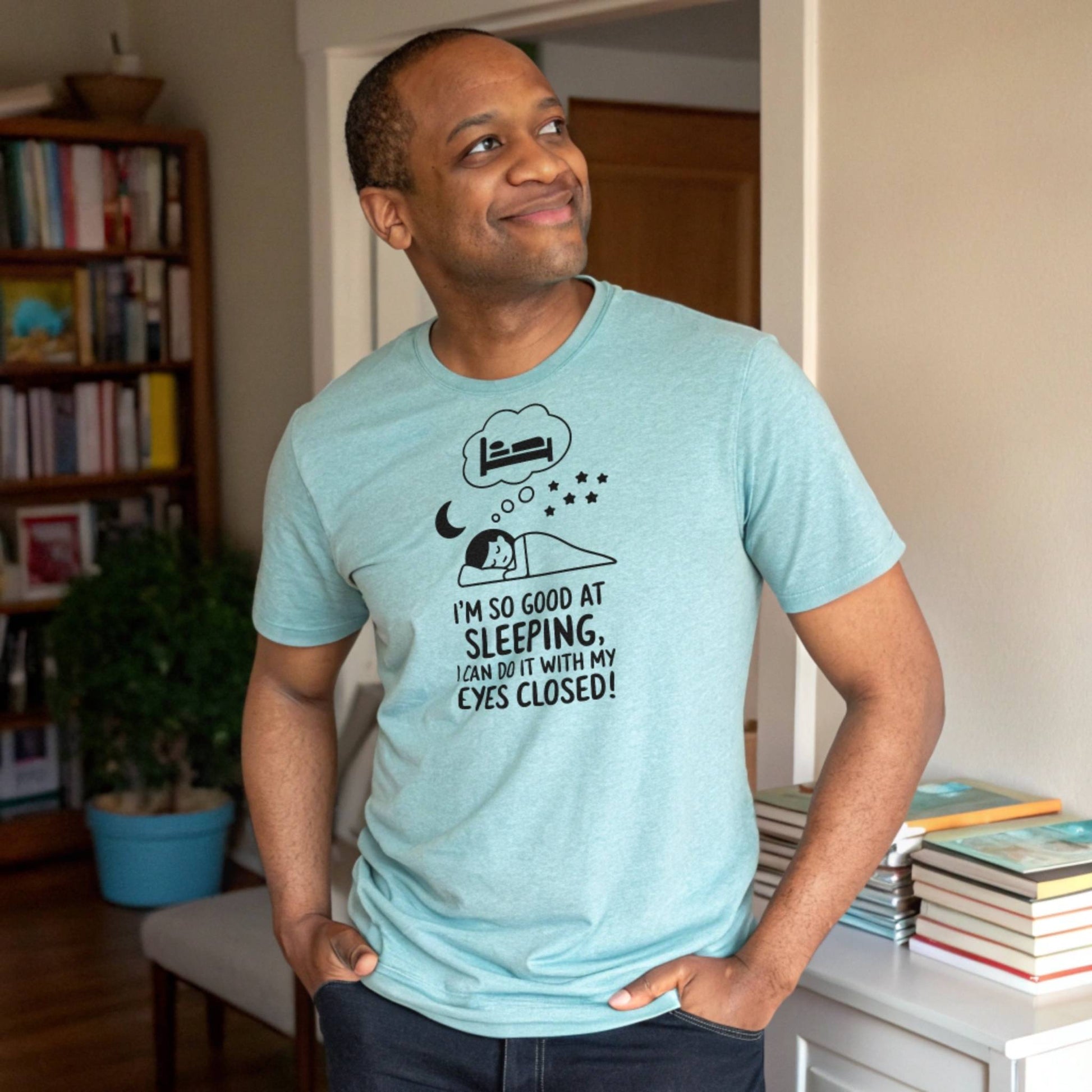 Man smiling in a heather clay "I'm so good at sleeping" t-shirt, embodying relaxed parent mental health and humor.