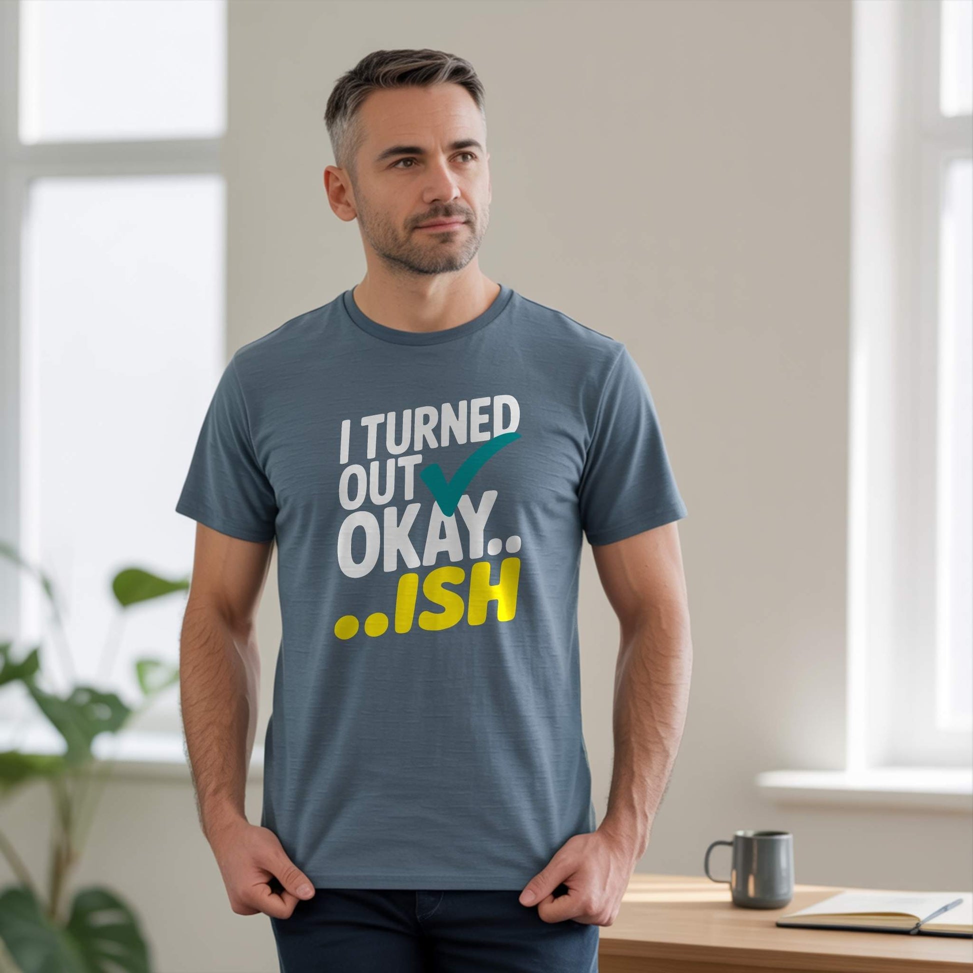 Man wearing a Heather Slate t-shirt with the "I Turned Out Okay...ish" design, for parents who laugh at the chaos.