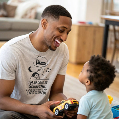 Father and child playing, dad in a heather dust "I'm so good at sleeping" t-shirt, embracing dad life and playful moments.